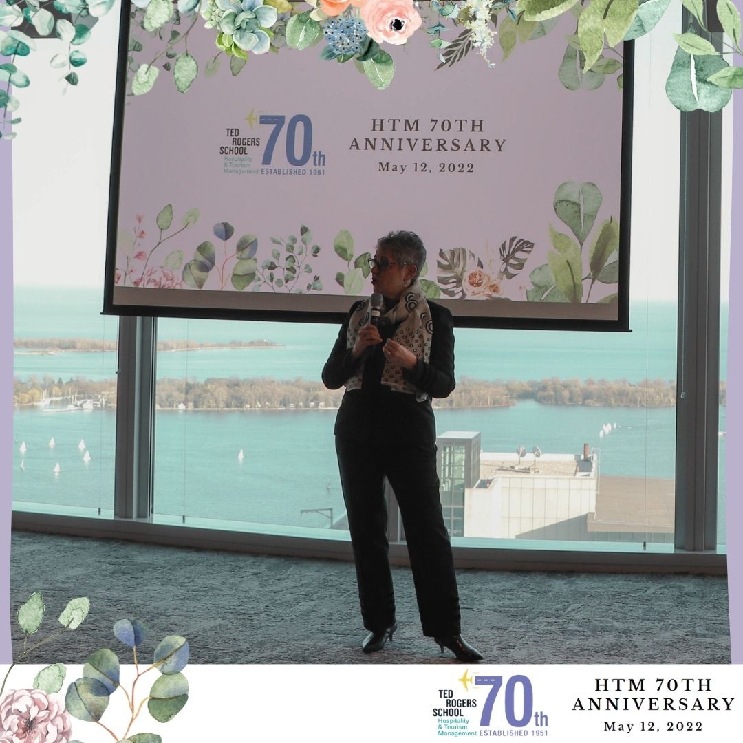 A woman is holding a microphone and speaking at HTM's 70th anniversary event.